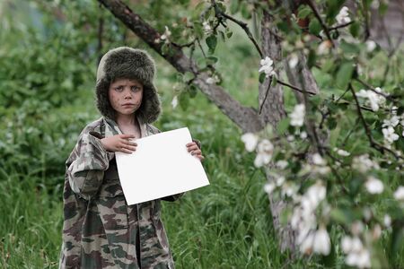 sad boy in uniform with white paperの写真素材
