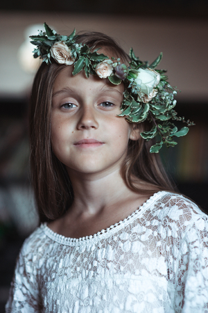 cute girl with very long hair and a beautiful wreath of flowers on her headの写真素材