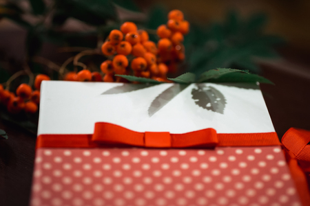 Postcard with a bow and a bouquet of mountain ash on blurred backgroundの写真素材