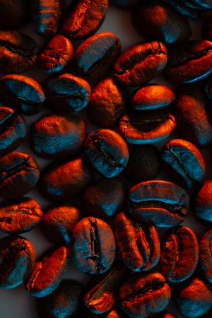 a scattering of coffee beans for the background illuminated with colored neonの写真素材