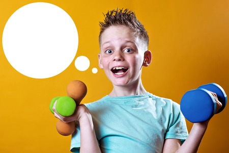 a boy in a blue t-shirt with dumbbells on a bright yellow backgroundの写真素材