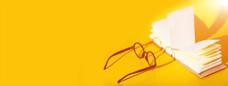 black round glasses on a yellow background with a hard shadow and the inscription lookの写真素材