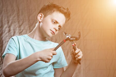a boy with a wrench and surprised eyes repairs somethingの写真素材