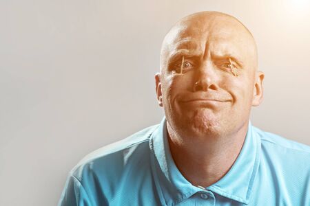 a bald brutal man in a light t-shirt put matches in his eyes and sleeps