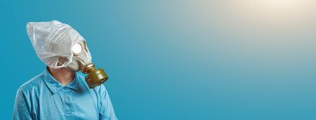 a man in a gas mask and a plastic bag on his head symbolizes the protection of the environment from pollution on a blue backgroundの写真素材