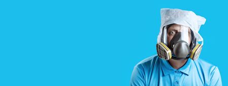 a man in a gas mask and a plastic bag on his head symbolizes the protection of the environment from pollution on a blue backgroundの写真素材