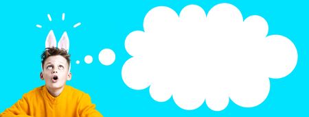 surprised boy in a yellow jacket and ears of a hare on blue background