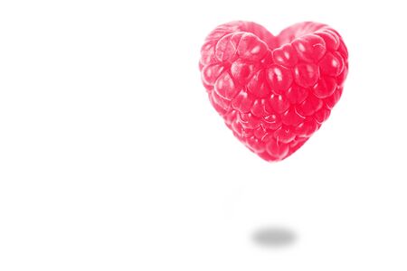 Raspberry in the shape of a heart with a shadow on a white background