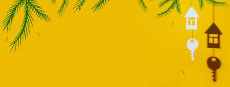 a small house and key made of cardboard casts a shadow on a bright colored backgroundの写真素材