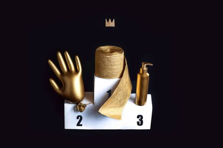 Gold glove, toilet paper and a sanitizer on a white bollard. Concept on the theme of coronavirus trends. Black background.の写真素材