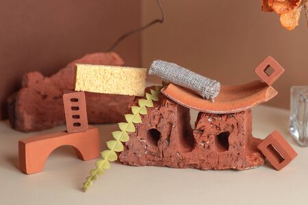 Geometric composition of bricks, glass bottle and plants. In a corner space of two colors