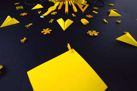A concept on the subject back to school. The students yellow stationery on a black backgroundの写真素材