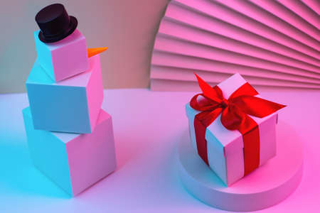 The polygonal snowman of cubes and gift is illuminated with neon light, against the background of...