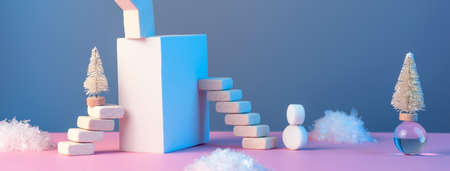 Winter New Years still life with stairs, Christmas tree, star, sun, snow and geometric shapes on a pink blue background, in a neon lightの写真素材