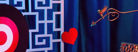 Small golden cupid marks his target with an arrow at the heart, valentines day concept.