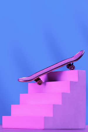 Skate in pink on the stairs, as a symbol of extreme sports, skateboarding, parkour, roller skates on a blue background with a place for text.の写真素材