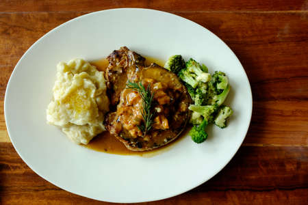 Top view of delicious grilled pork chops with mash potato and steamed green broccoli on brown wood tableの写真素材