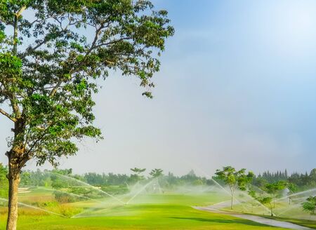 Irrigation sprinkle  system watering in fairway tee off and green of golf courseの写真素材