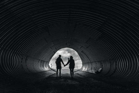 Couple walking together through a railway tunnel.の写真素材