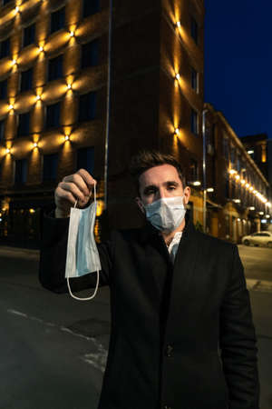 brunette in a medical mask holds a maskの写真素材