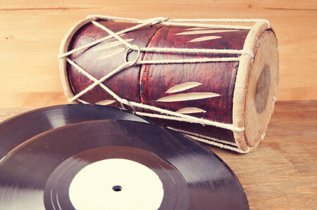 Vintage acoustic guitar, drum and vinyl record on a wooden background