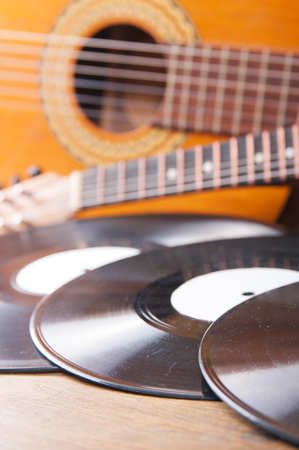 Vintage acoustic guitars and vinyl records on a wooden backgroundの写真素材