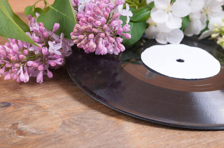 Vinyl record and spring flowers on the tableの写真素材