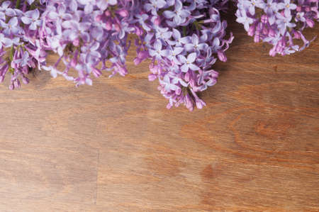 Background from a bouquet of lilacs on a wooden tableの写真素材