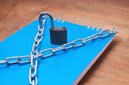 Blue notebook, tied with chains with lock, the concept of information securityの写真素材