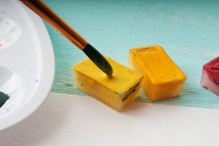 A man takes a brush watercolor paint before paintingの写真素材