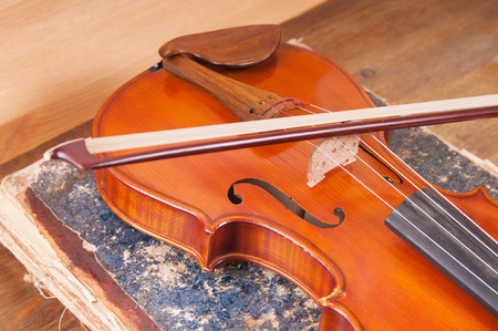 Violin, bow and old book tableの写真素材