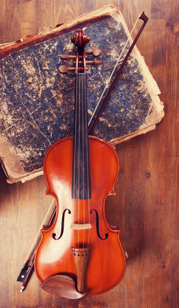 Violin, bow and old book tableの写真素材