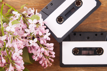 Audio cassette and spring flowers on a wooden tableの写真素材