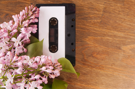 Audio cassette and spring flowers on a wooden tableの写真素材
