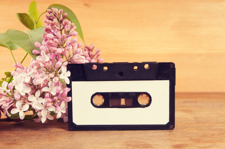 Audio cassette and spring flowers on a wooden tableの写真素材