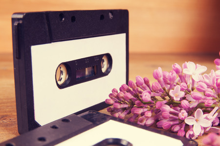 Audio cassette and spring flowers on a wooden tableの写真素材