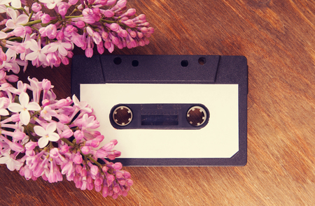 Audio cassette and spring flowers on a wooden tableの写真素材