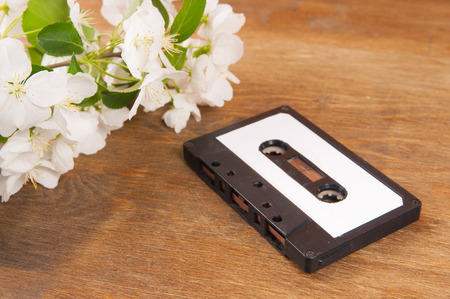 Audio cassette and spring flowers on a wooden tableの写真素材