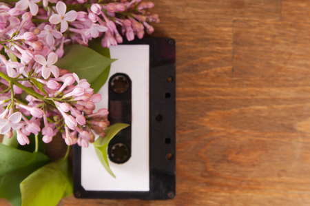 Audio cassette and spring flowers on a wooden tableの写真素材