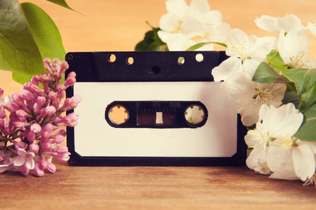 Audio cassette and spring flowers on a wooden tableの写真素材