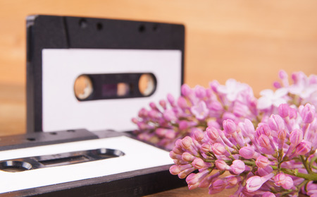 Audio cassette and spring flowers on a wooden tableの写真素材