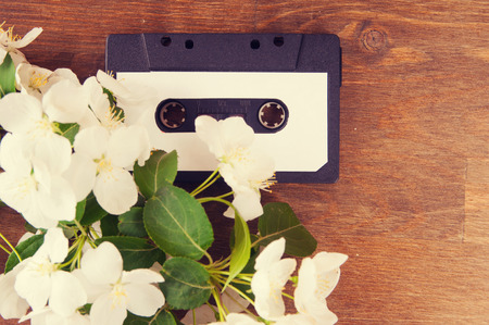 Audio cassette and spring flowers on a wooden tableの写真素材