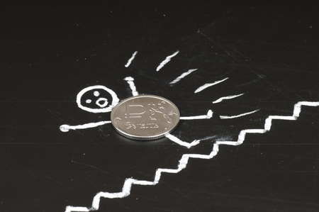 Financial collapse concept - frightened coin falls from laddersの写真素材