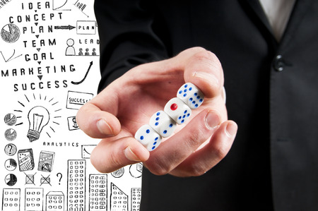 close up of mans hand holding white casino dice
