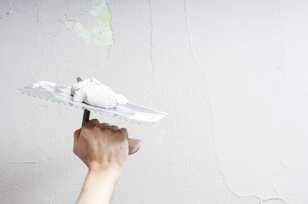 Hands Plasterer at work. Application of the plaster on the wall. textured plasterの写真素材
