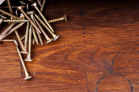 Yellow passivated screws on wood deskの写真素材