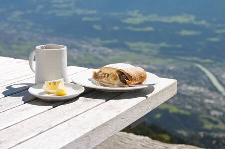 Strudel and lemon cup of tea on a table in a cafe in the mountains, the Alpsの写真素材