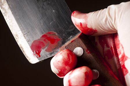 The bloody knife in hand in gloveの写真素材