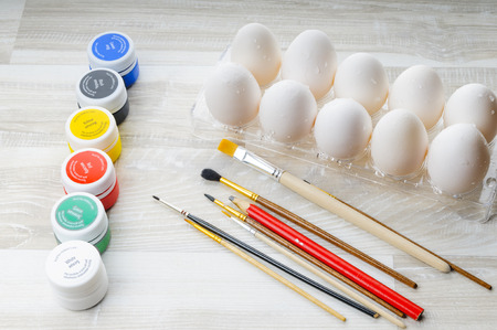 Eggs, paint and paint brush on the table. Preparation for Easter