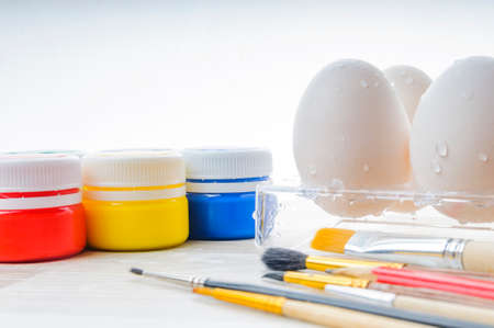 Eggs, paint and paint brush on the table. Preparation for Easter